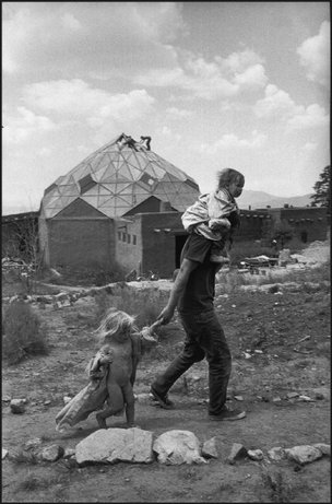 NEW MEXICO—At the Lama Foundation community, a father and two children pass in front of the kitchen, a stoutly built octagonal wood and glass structure (geodesic dome) with all the things a kitchen should have, plus a dining room above, 1971. © Henri Cartier-Bresson / Magnum Photos