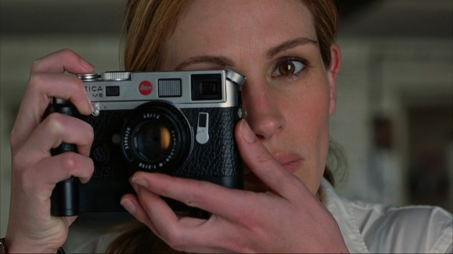 Julia Roberts shooting Natalie Portman with a chrome Leica M6 TTL and 50mm Summicron; from the movie Closer (2004)