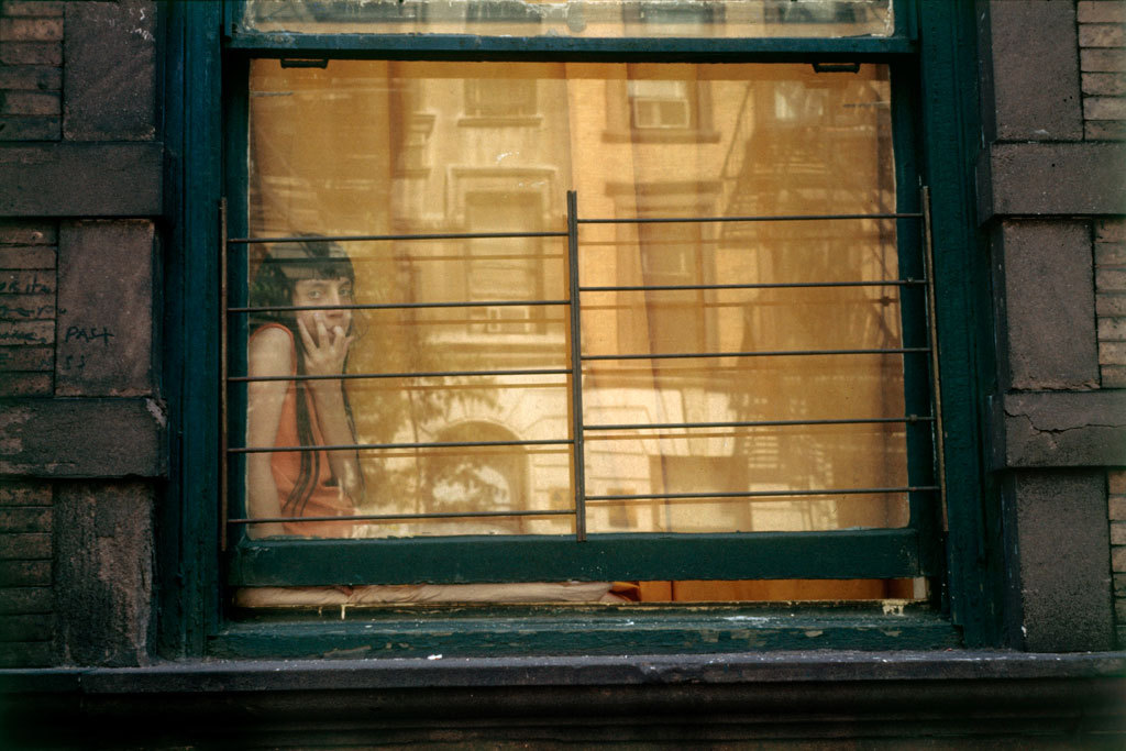 Girl in window, orange reflection, New York, 1972 © Helen Levitt